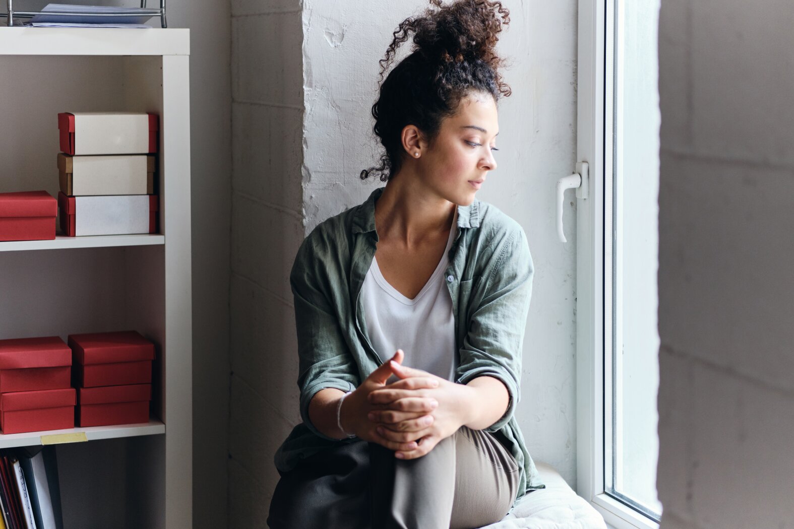 Woman reflecting by a window